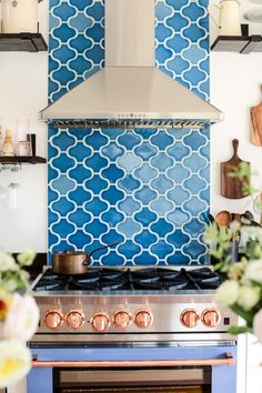 a stove top oven sitting inside of a kitchen next to a wall mounted range hood