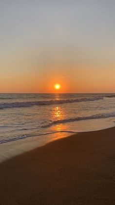 the sun is setting over the ocean with waves