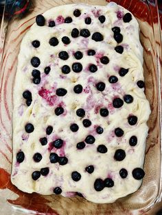 blueberries and cream cheese are spread on top of the dough in a baking pan