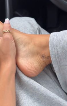 a woman's foot with a small tattoo on her left ankle and right leg