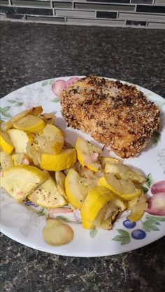 a white plate topped with meat and potatoes next to a piece of fried chicken on top of a flowered plate