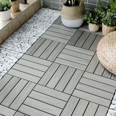 an outdoor area with plants and rocks on the ground, including potted plants in wicker baskets