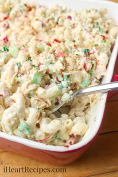 a red casserole dish filled with macaroni salad