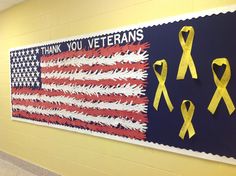 an american flag with yellow ribbons hanging on the wall