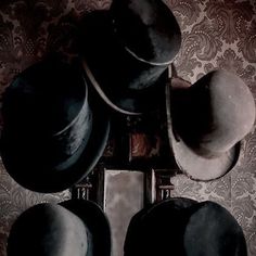 a group of hats sitting on top of a wooden table next to a mirror in a room