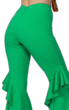 a woman wearing green pants with ruffles on the bottom and one leg up