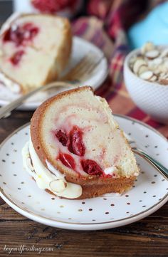 a piece of cake on a plate with some nuts and strawberries in the background