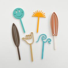 four different types of cookie cutters on a white surface, one with a smiley face and the other with a spoon