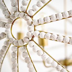 a close up view of some white beads on a chandelier with gold accents