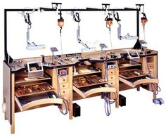 a row of wooden drawers with multiple machines on them and lights hanging from the ceiling