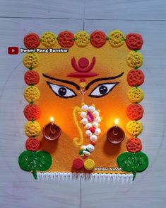 a decorated diya with eyes and lights on the face for ganeshi festival