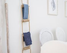 there is a rope shelf with towels hanging on it and two chairs next to it