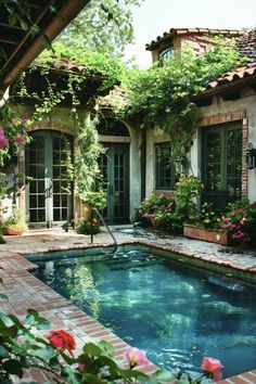 an outdoor swimming pool surrounded by greenery and brickwork with roses growing on the side