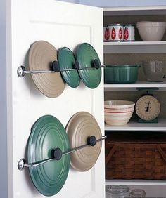 an image of a kitchen cupboard with pots and pans on it's doors