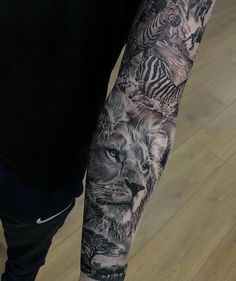 a man with a tattoo on his arm that has animals and zebras on it