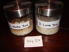 two jars with labels on them sitting on a table next to a note that says i hate you, i love you