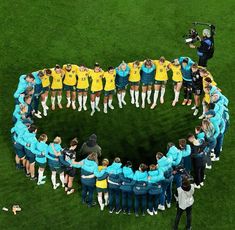 a group of people standing in a circle on top of a field