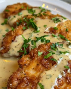 chicken with gravy and parmesan sauce on a white plate