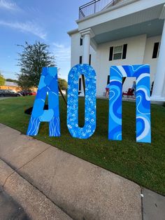 the letters are painted blue and white in front of a large building that says aqua