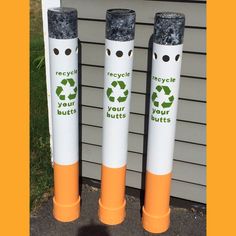 three orange and white poles with recycle your butts stickers on them