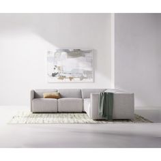 a living room with a gray couch and white rugs on the floor in front of a painting