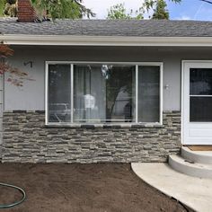 a house that has some dirt in front of it and a hose attached to the door