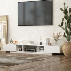 a flat screen tv mounted to the side of a wall in a living room next to a potted plant