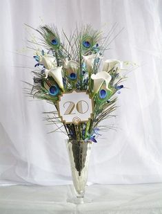 a vase filled with white flowers and peacock feathers