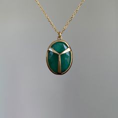 A sumptuous green emerald encased in Rachel Atherley's signature scarab beetle motif setting. 14k yellow gold Emerald 11mm x 15mm (1/2" x 11/16") Chain is 16" long