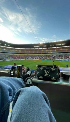 a person's feet resting on the edge of a seat at a baseball stadium