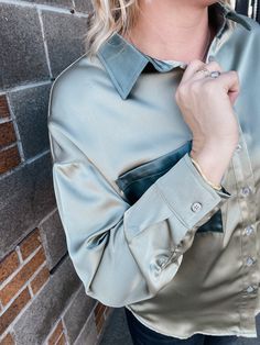 Be sure to turn heads in this gorgeous blouse. The silky look is a trend we are loving. model wearing small color sage Satin Button-up Top With Buttons, Green Silk Blouse With Button Closure, Solid Color Silk Button-up Tops, Green Silk Button-up Blouse, Light Wash Button-up Blouse With Button Closure, Gorgeous Blouses, We Are Love, Button Up, Turn Ons