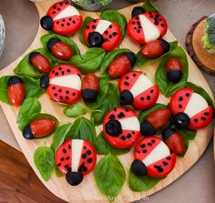 ladybug cookies are arranged on a wooden board