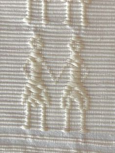 an embroidered piece with white thread on it