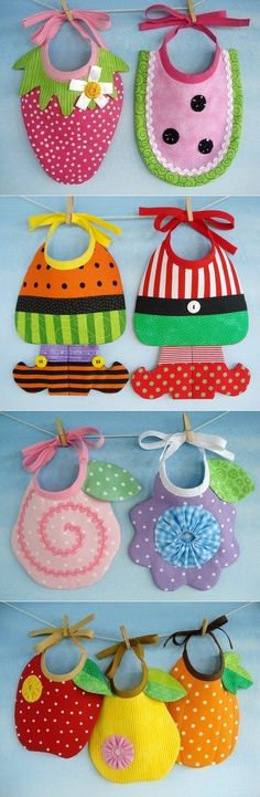 several baby bibs are hanging on the clothes line in different colors and patterns,