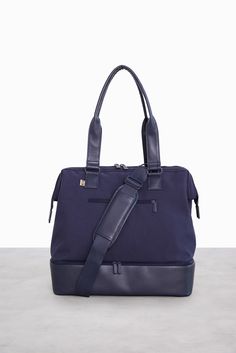 The Mini Weekender in Navy | Beis Travel – Béis Practical Weekender Bag With Adjustable Strap For Travel, Modern Rectangular Gym Bag For Travel, Versatile Gym Bag With Luggage Sleeve For Weekend Trips, Versatile Gym Bag With Adjustable Strap For Overnight Trips, Functional Weekend Travel Bag With Luggage Sleeve, Sporty Tote Weekender Bag, Sporty Tote Weekender Bag For Weekend Trips, Sporty Weekender Tote Bag For Weekend Trips, Modern Gym Bag With Luggage Sleeve For On-the-go