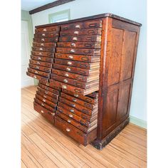 an old wooden filing cabinet sitting on top of a hard wood floor