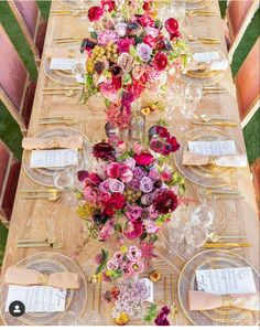 a long table is set with flowers and place settings for the guests to sit at