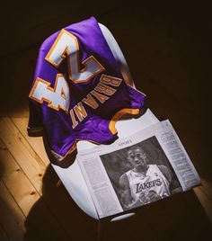 the lakers jersey is laying on top of a newspaper