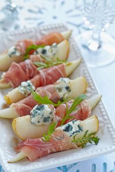 appetizers with prosciutto, pears and blue cheese on a white platter