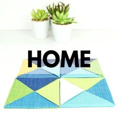 two potted plants sitting next to each other on top of a white table with the words home