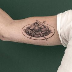 a man's arm with a plate of spaghetti and pears tattoo on it