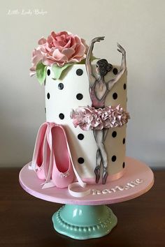 a cake decorated with ballet shoes and a ballerina