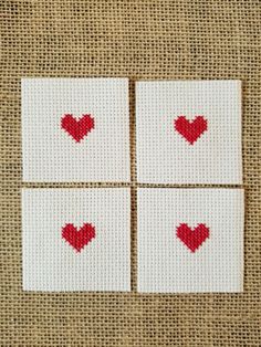 four squares with red hearts on them are arranged in the shape of small squares