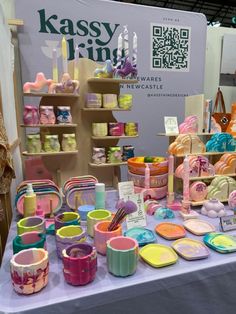 there are many cups and plates on display at this trade show that is very colorful