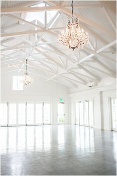 an empty room with chandeliers and windows