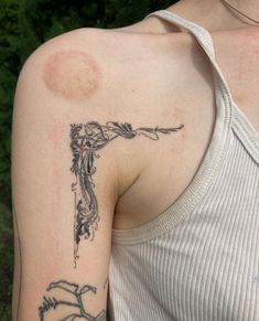 a woman with a tattoo on her arm holding a knife in one hand and an arrow in the other