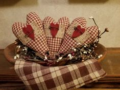 several hearts are placed in a basket on a table with a checkered cloth and twine