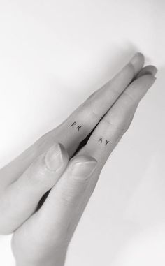 two fingers with small tattoos on them