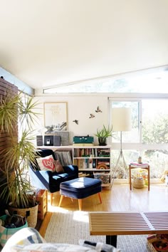 a living room filled with furniture and a book shelf on top of a hard wood floor