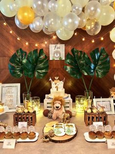 a table topped with lots of desserts and balloons